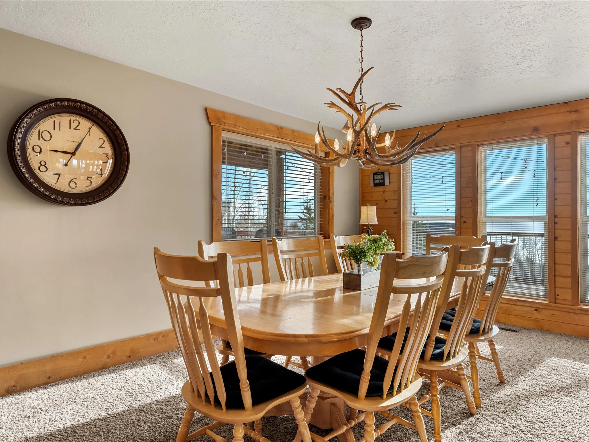 Carpeted dining room with a chandelier, a textured ceiling, and wooden walls