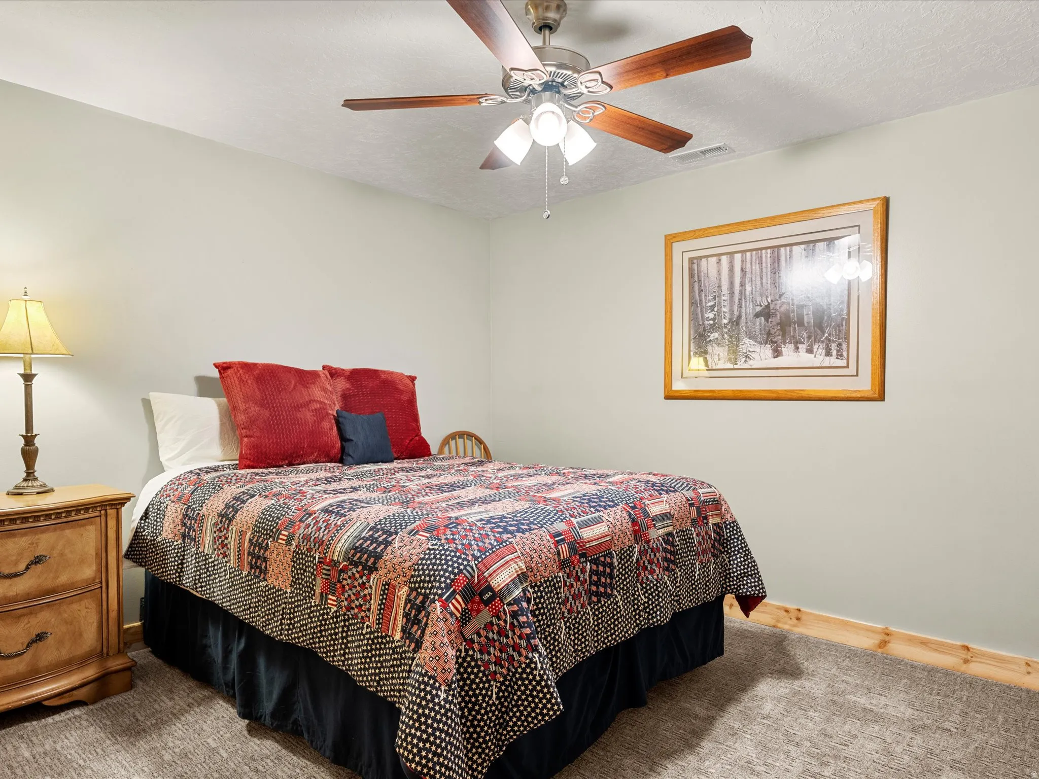 Bedroom featuring a textured ceiling, carpet floors, and a ceiling fan