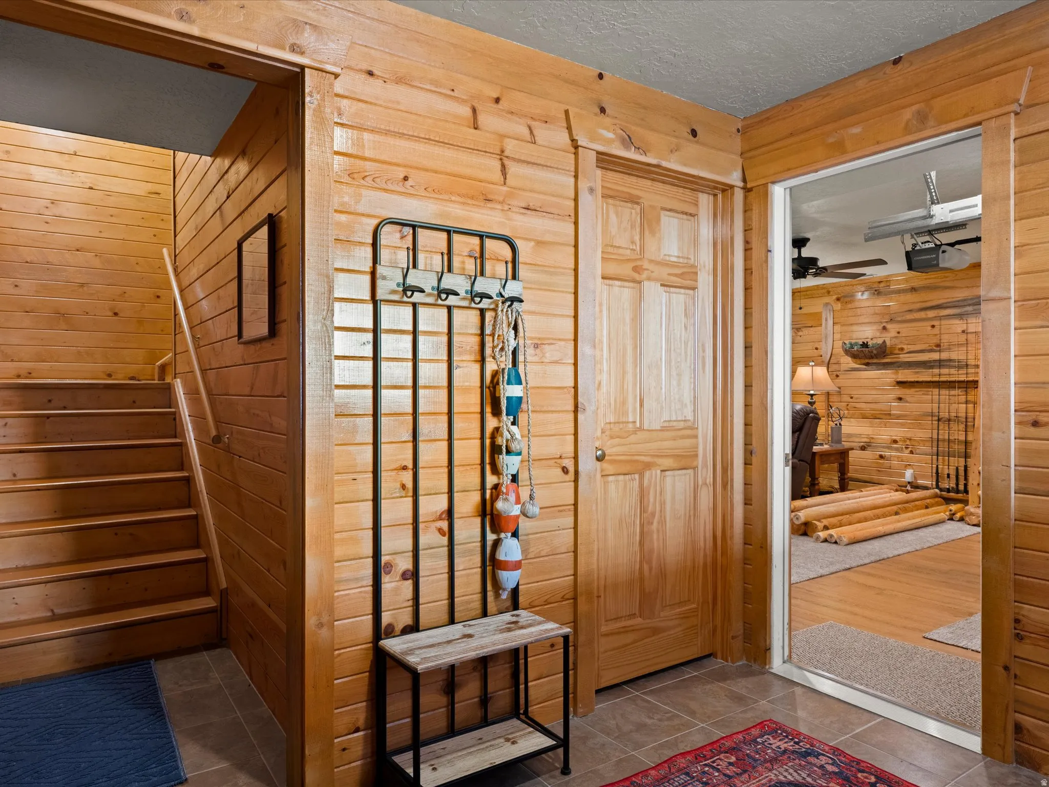 Entryway featuring wooden walls, tile patterned floors, and a textured ceiling