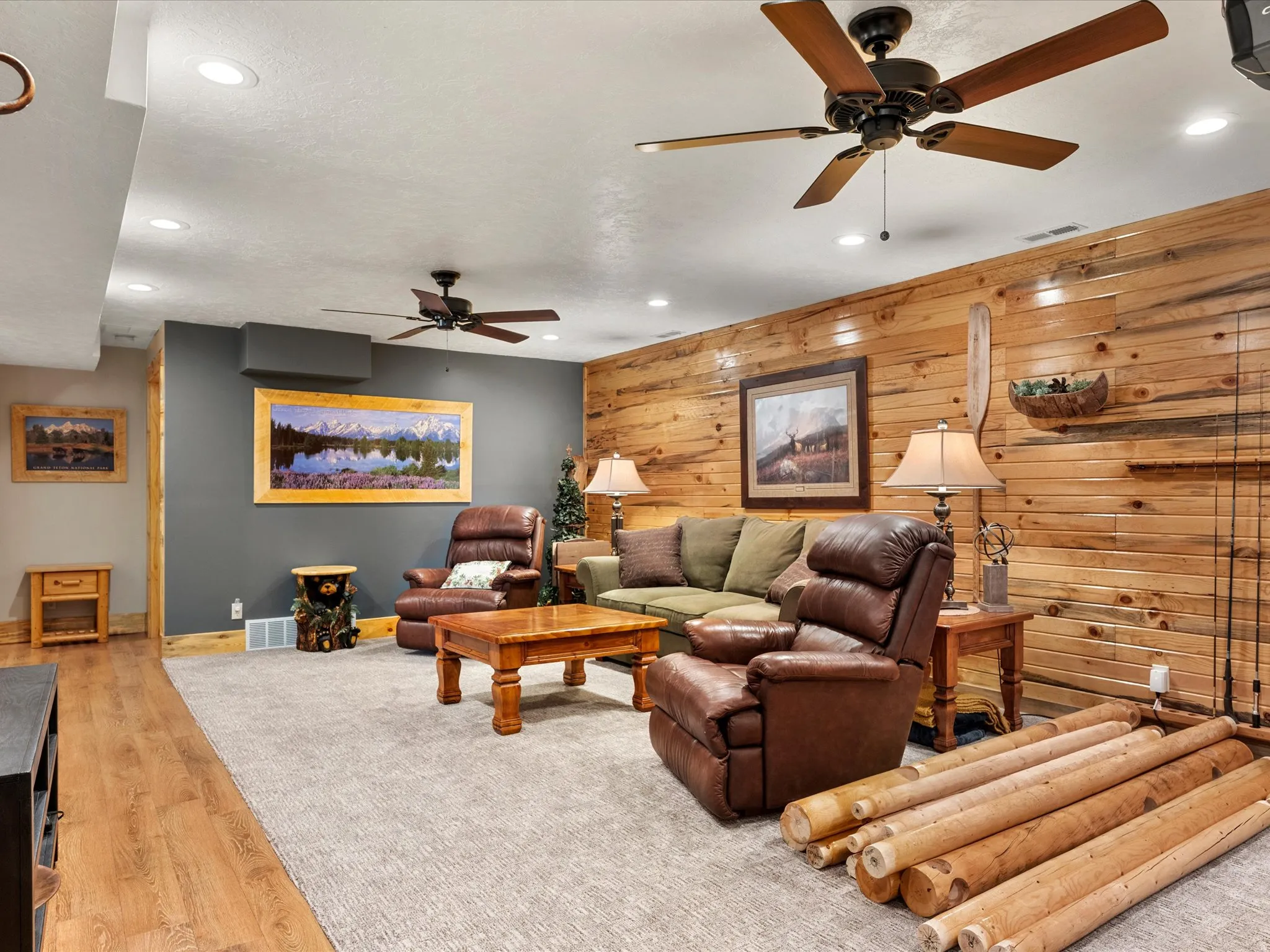 Living room featuring recessed lighting, ceiling fan, wooden walls, and light wood-style flooring