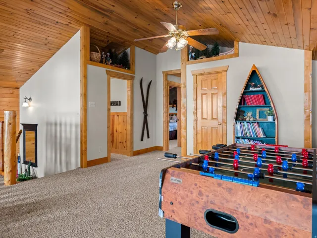Recreation room featuring a vaulted wooden ceiling, ceiling fan, and carpet