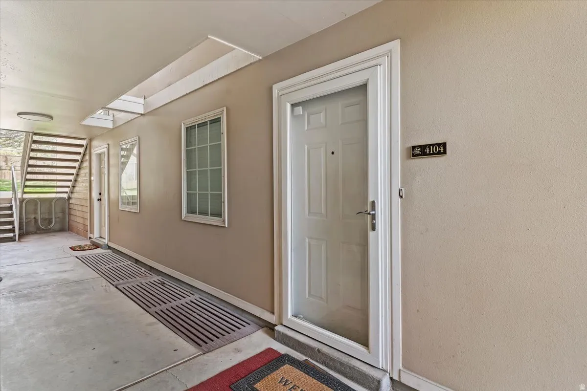 Doorway to property featuring stucco siding and a patio area