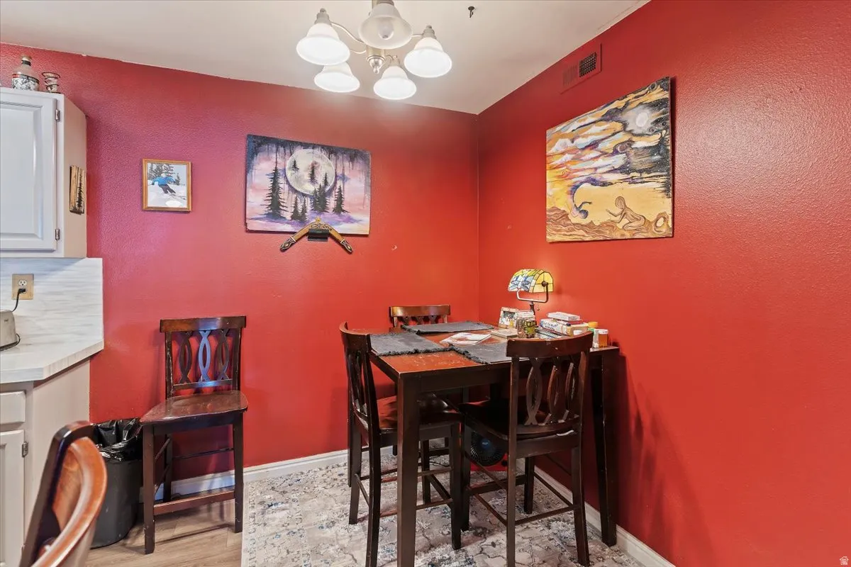 Dining area with suspended lighting and light wood-style flooring
