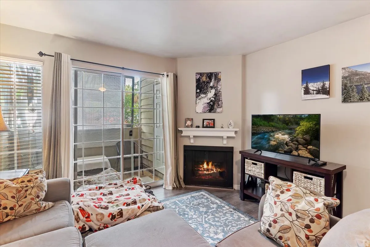 Living area featuring wood finished floors and a lit fireplace