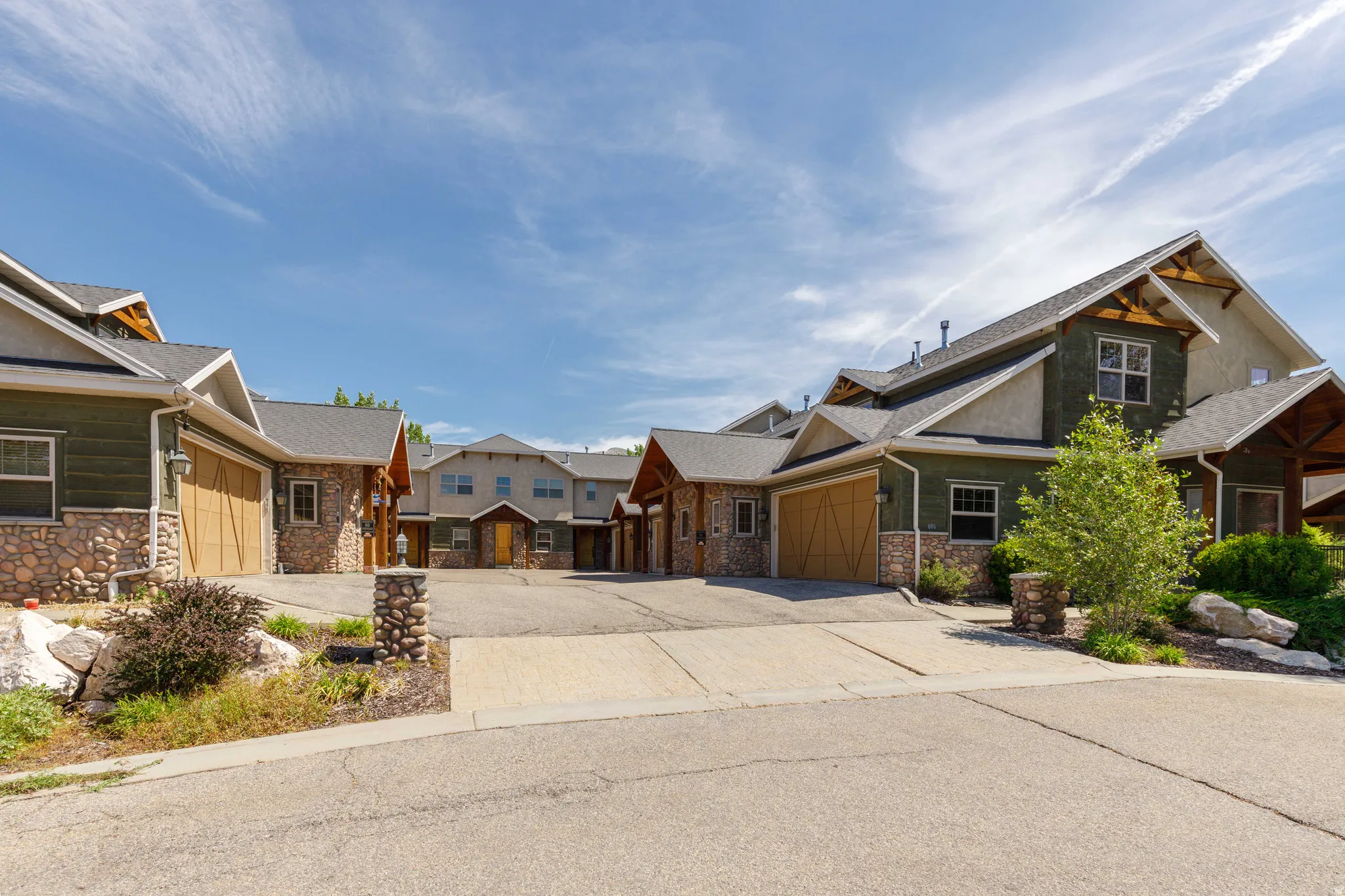 Stone and siding exterior with wood garage doors