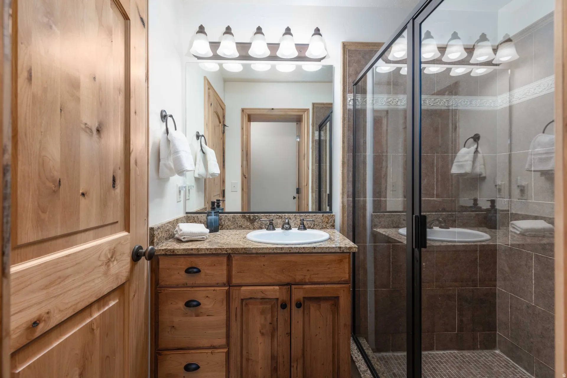 Full bathroom with vanity and a shower stall