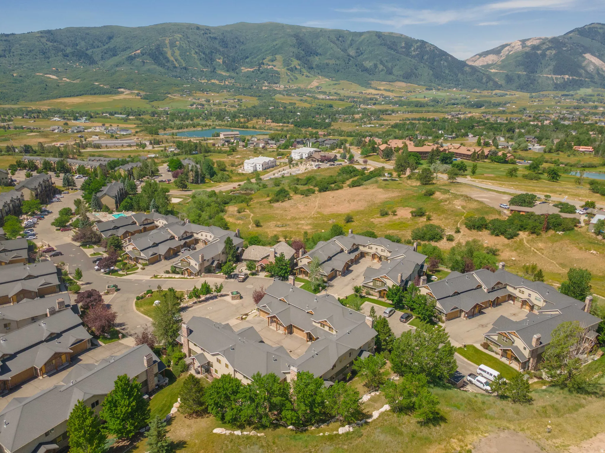 Aerial perspective showcasing a community of properties with gray roofs and natural-toned siding