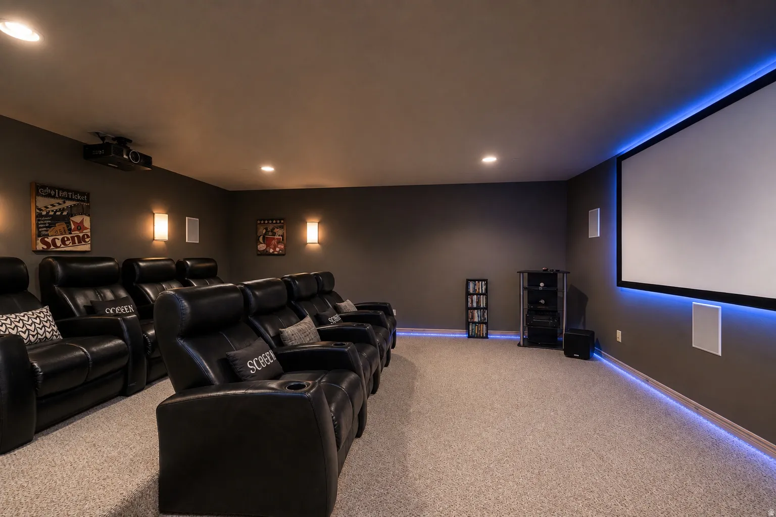 Home theater featuring a large projection screen, recessed lighting, wall sconces, and ambient perimeter lighting