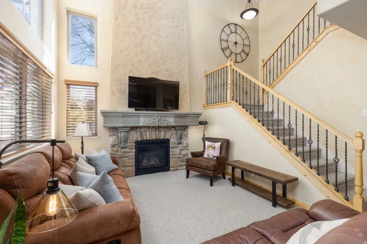 Living area featuring a high ceiling, carpet flooring, and a fireplace