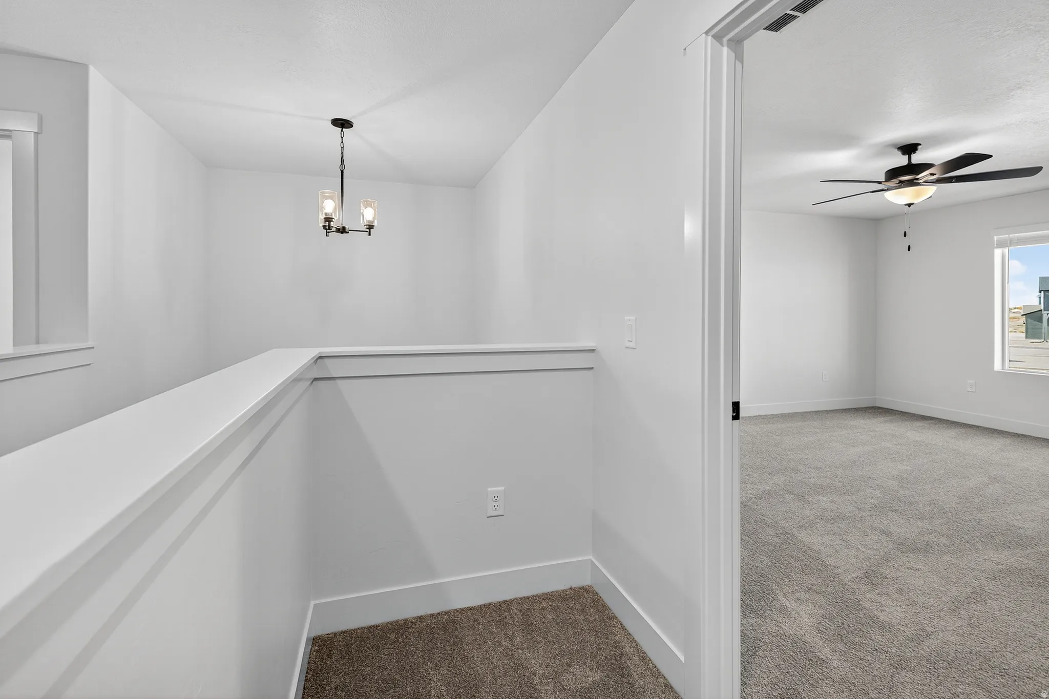 Hall featuring carpet flooring and a chandelier