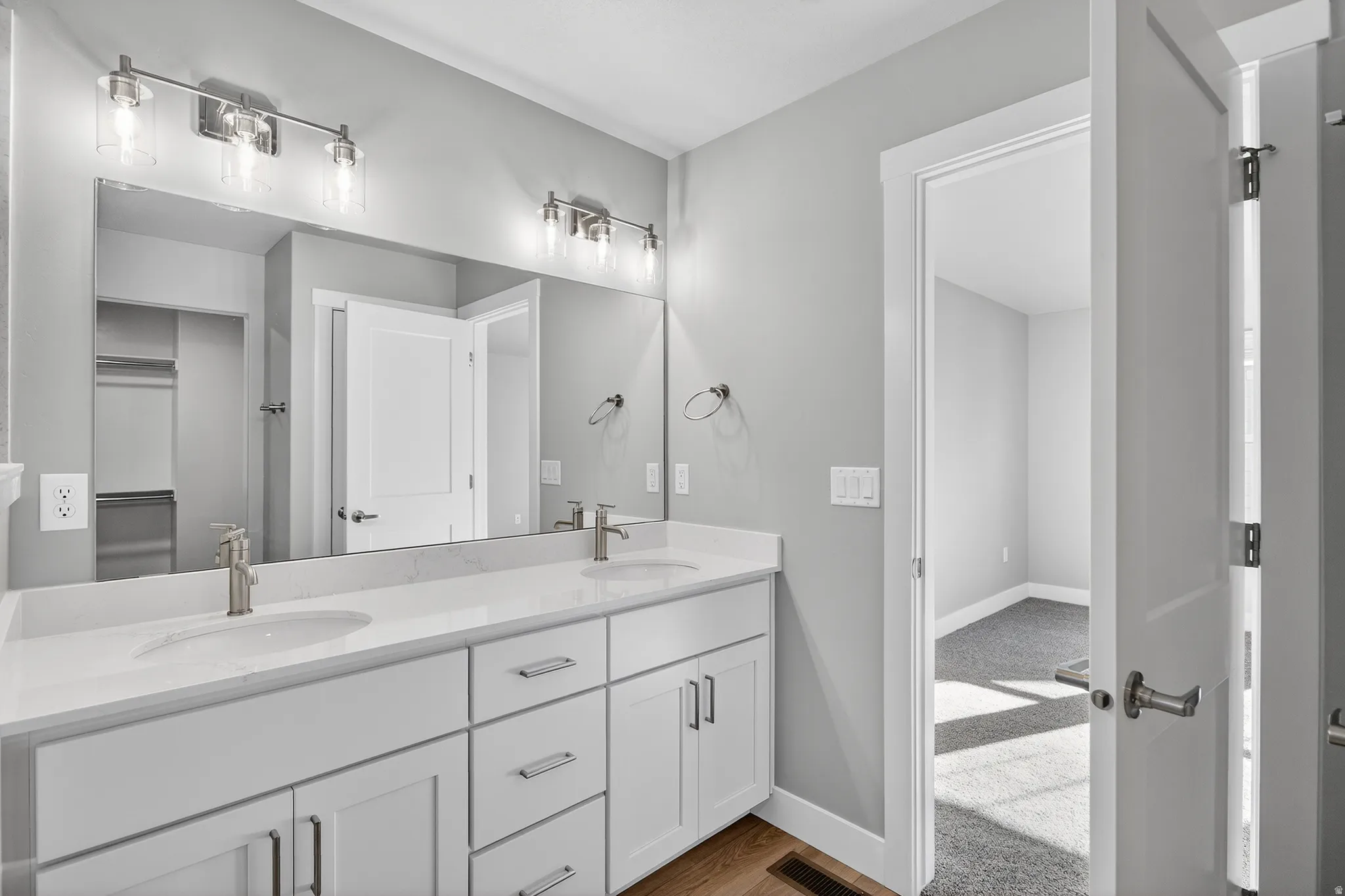 Bathroom featuring double vanity and light wood-type flooring