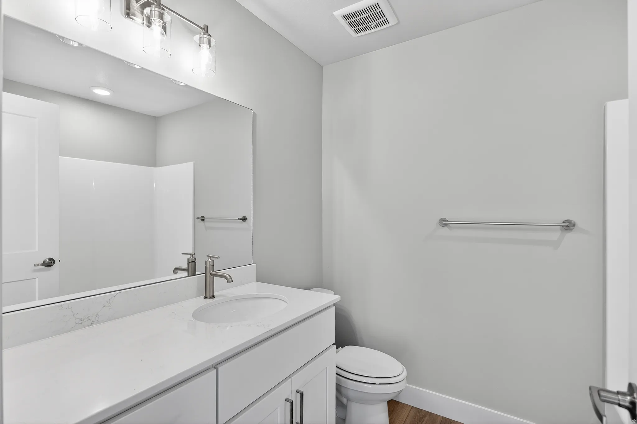 Bathroom featuring vanity, dark wood finished floors, and a shower