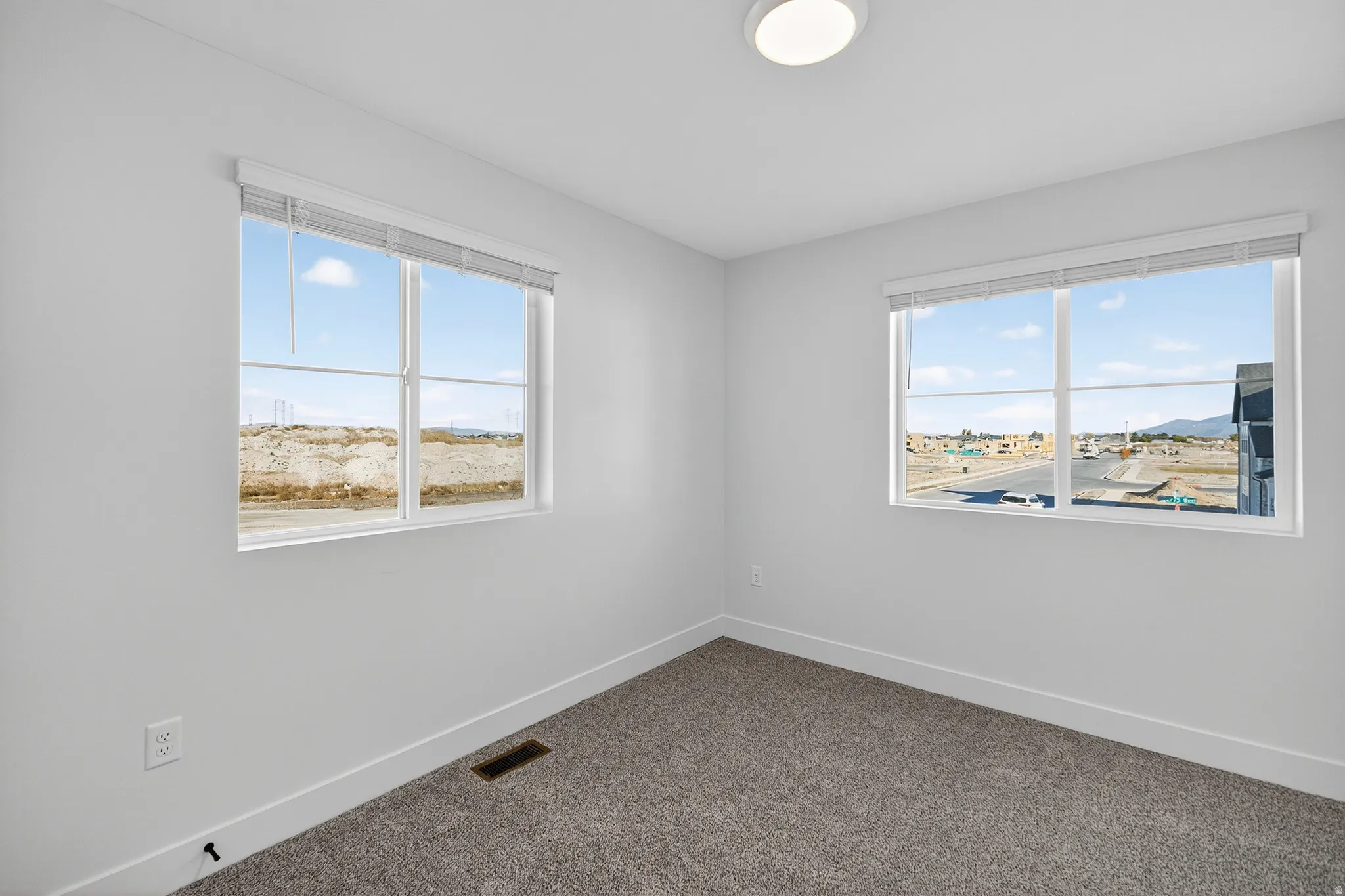 Spare room with dark carpet and plenty of natural light