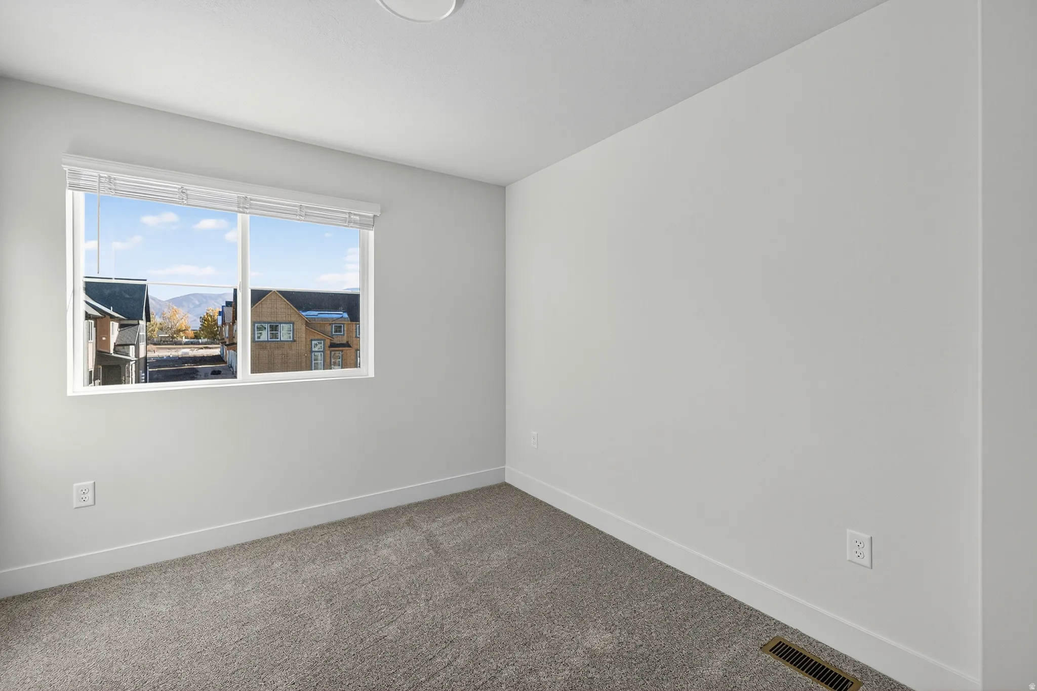 Empty room with carpet floors and a mountain view