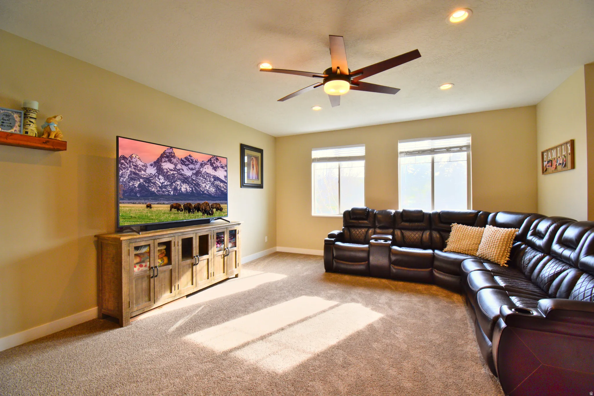 Carpeted living room with a ceiling fan and recessed lighting