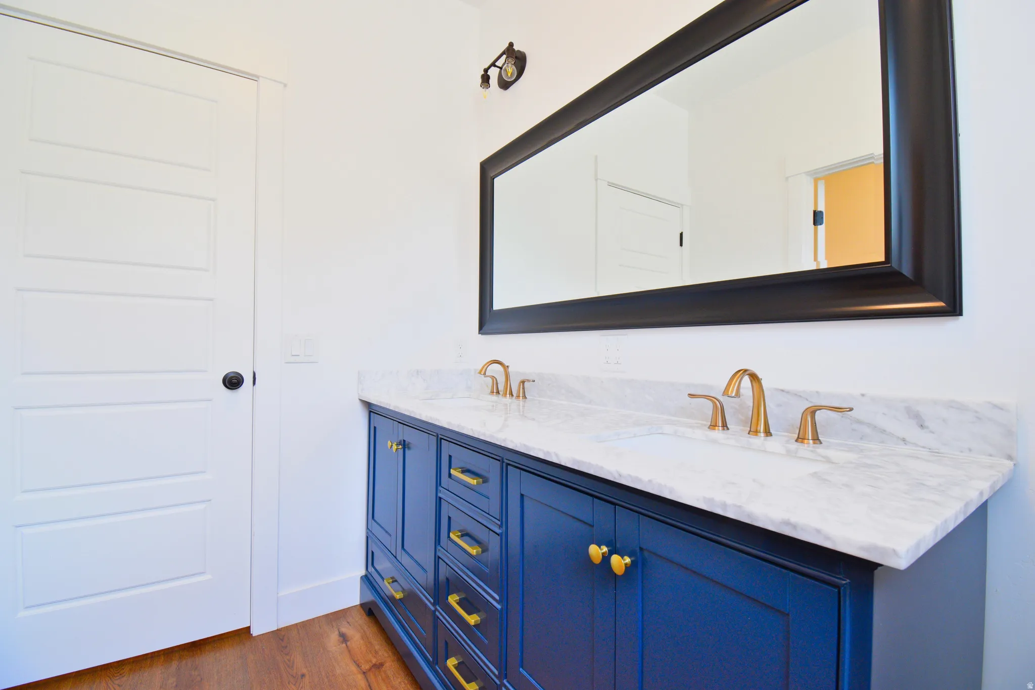 Full bathroom featuring double vanity and dark wood-style floors