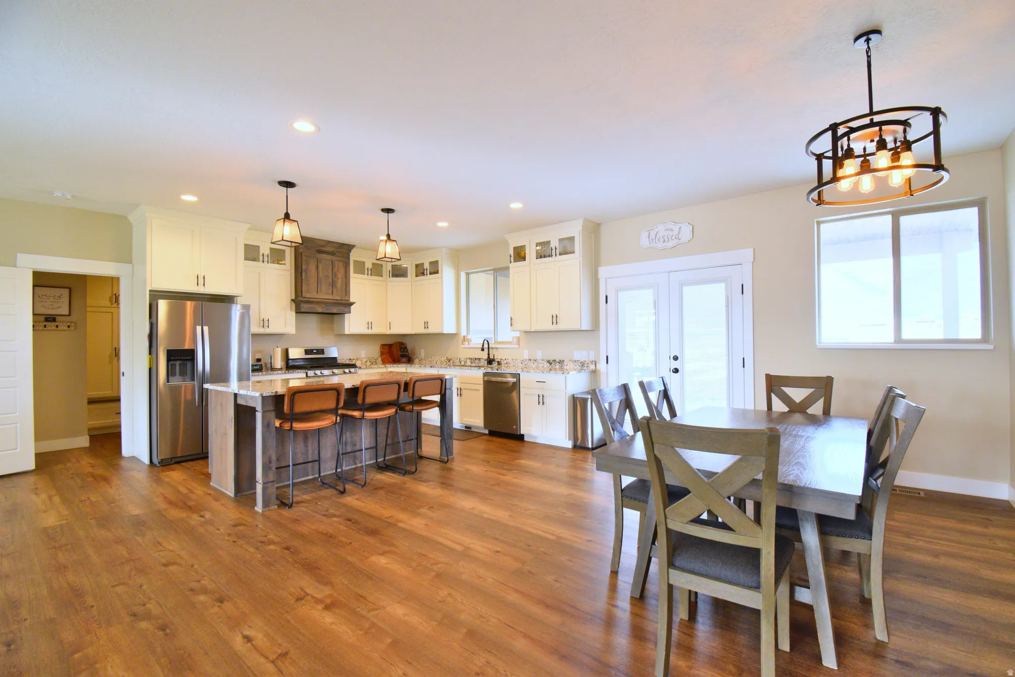 Dining area featuring dark wood-type flooring, suspended lighting, and french doors