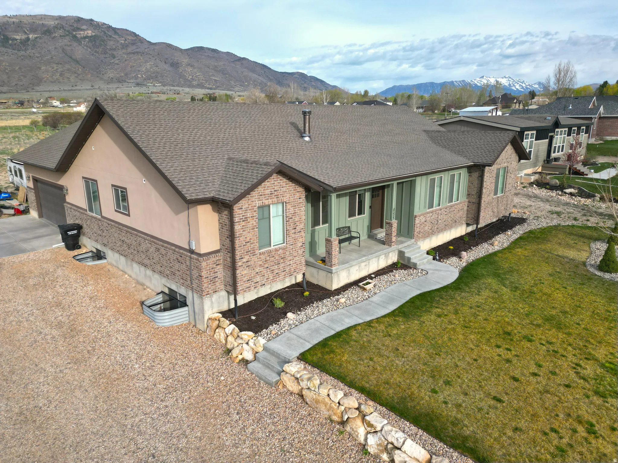 Rear view of property with brick siding, roof with shingles, a mountain view, and covered porch