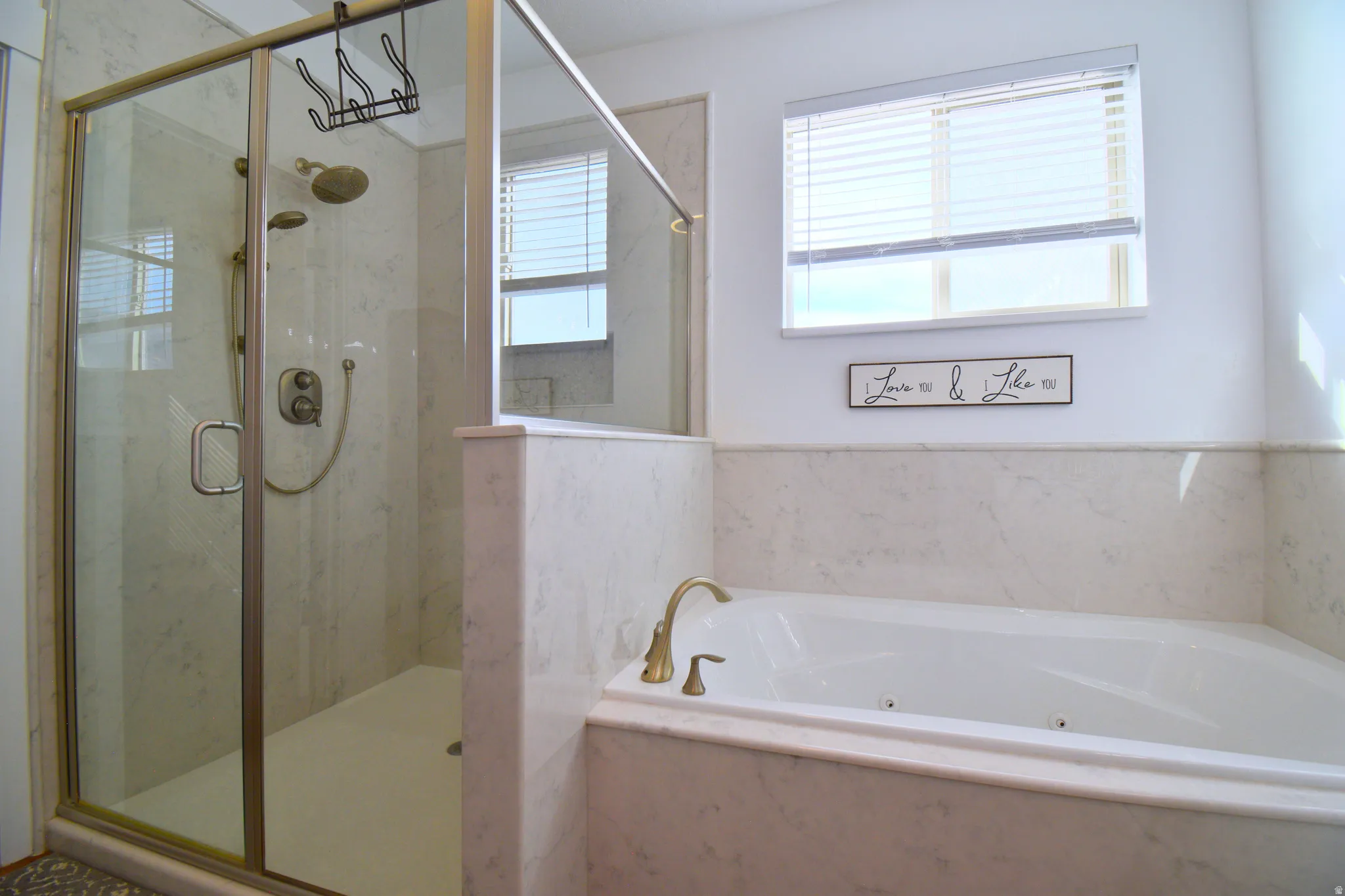 Bathroom with a marble finish shower and a whirlpool tub