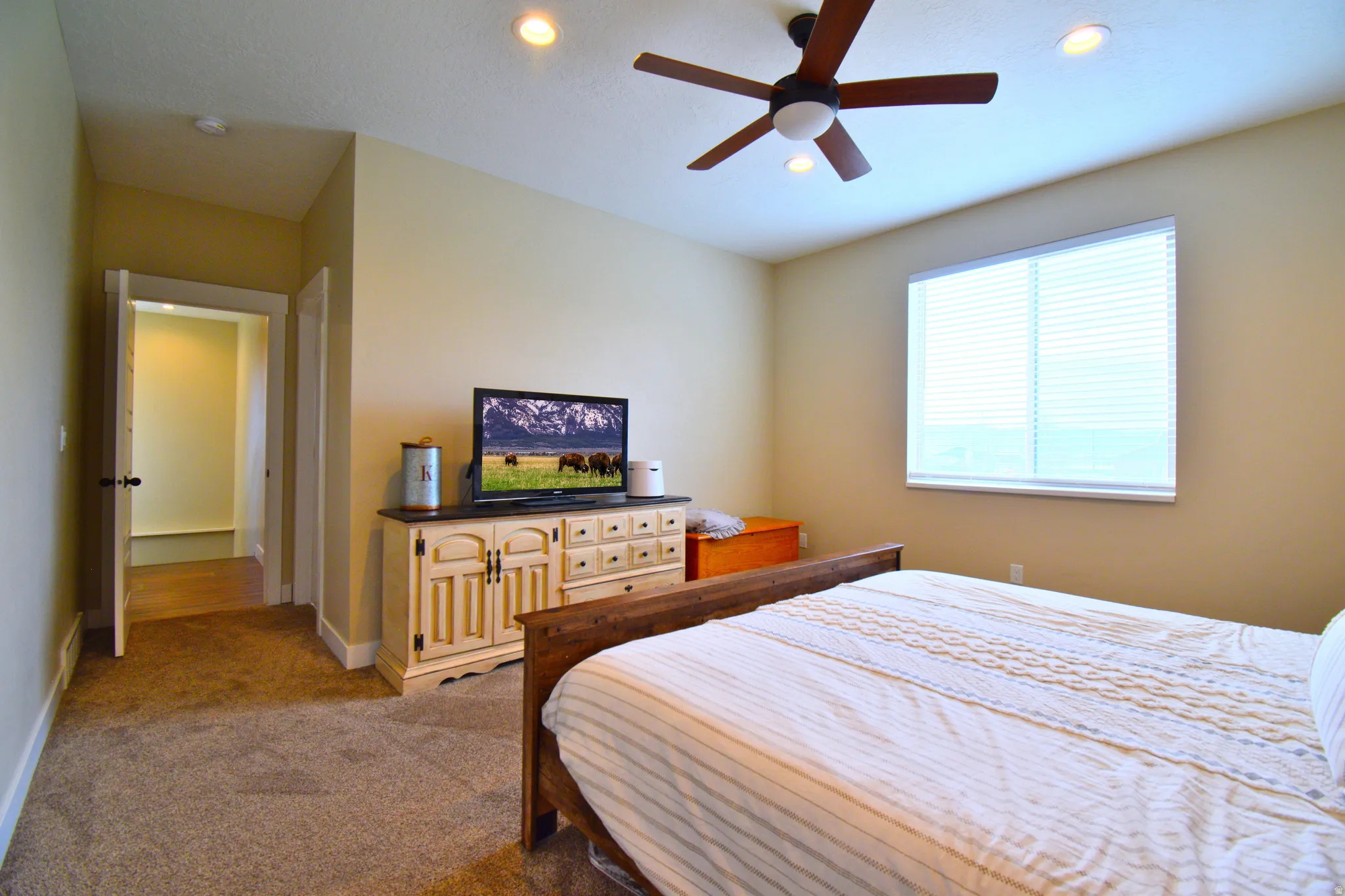 Bedroom with dark colored carpet, recessed lighting, and a ceiling fan