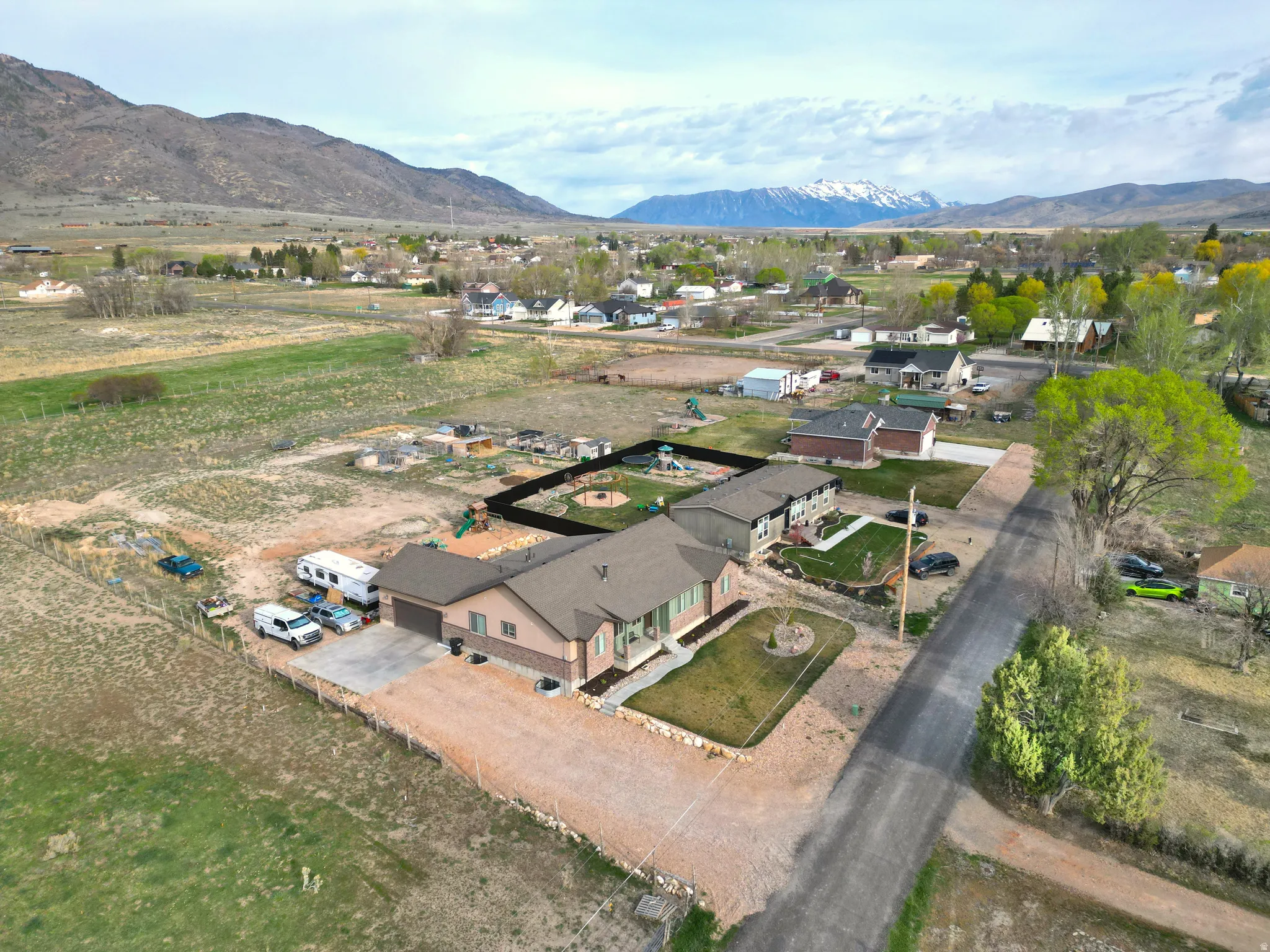 Aerial view of property and surrounding area with a mountainous background and nearby suburban area