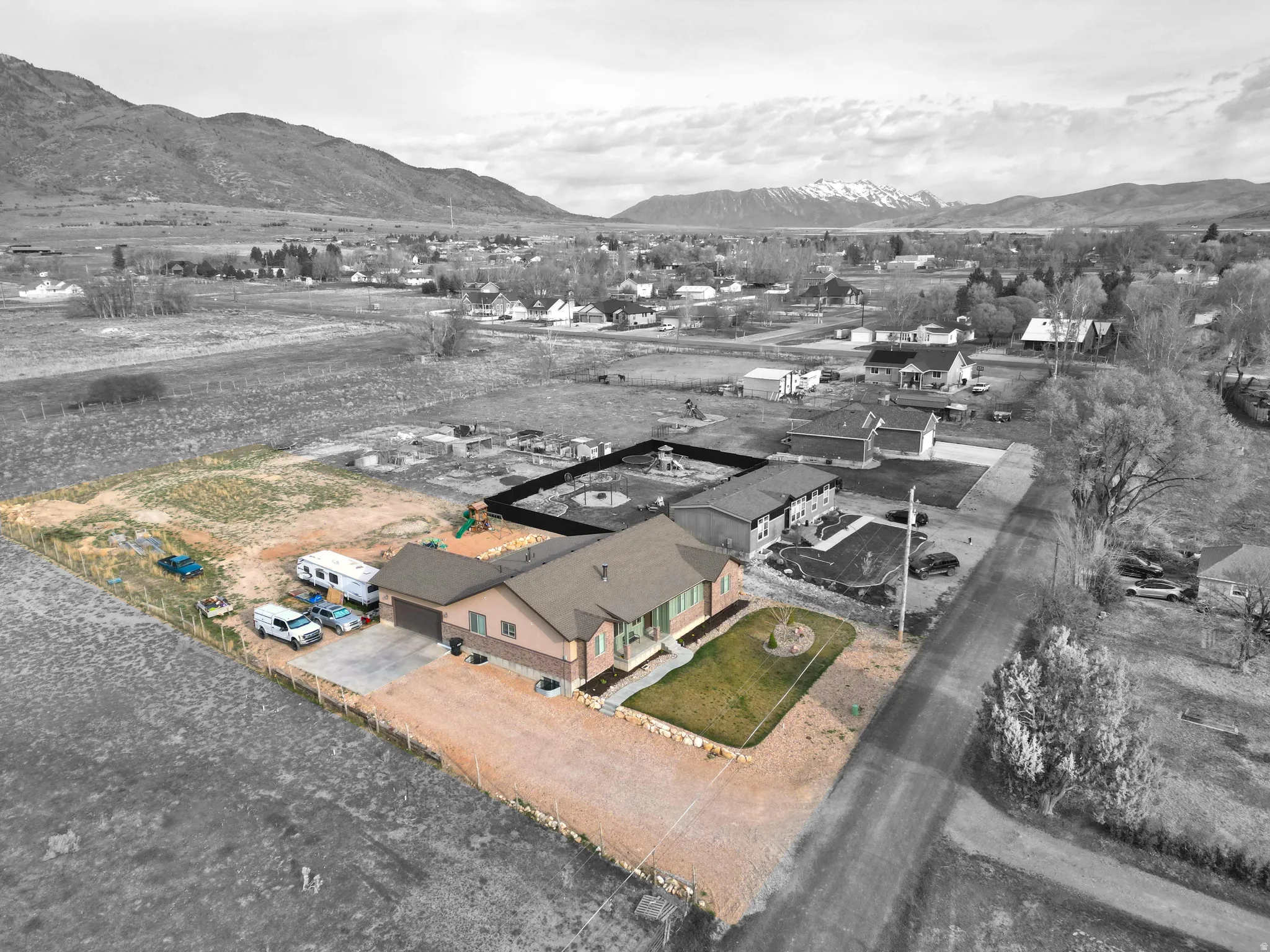 Aerial view of property and surrounding area with a mountainous background and nearby suburban area