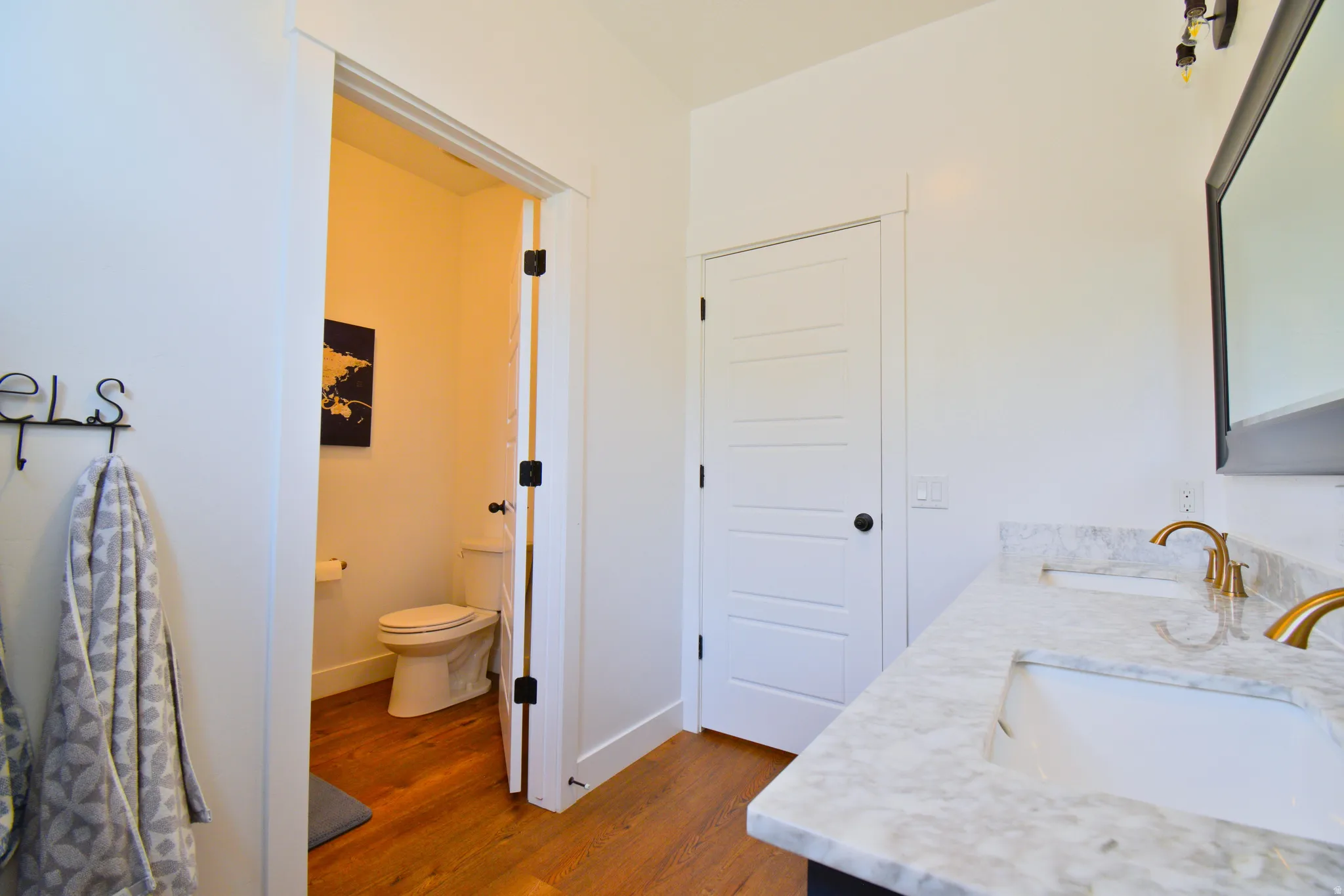 Bathroom with double vanity and dark wood finished floors