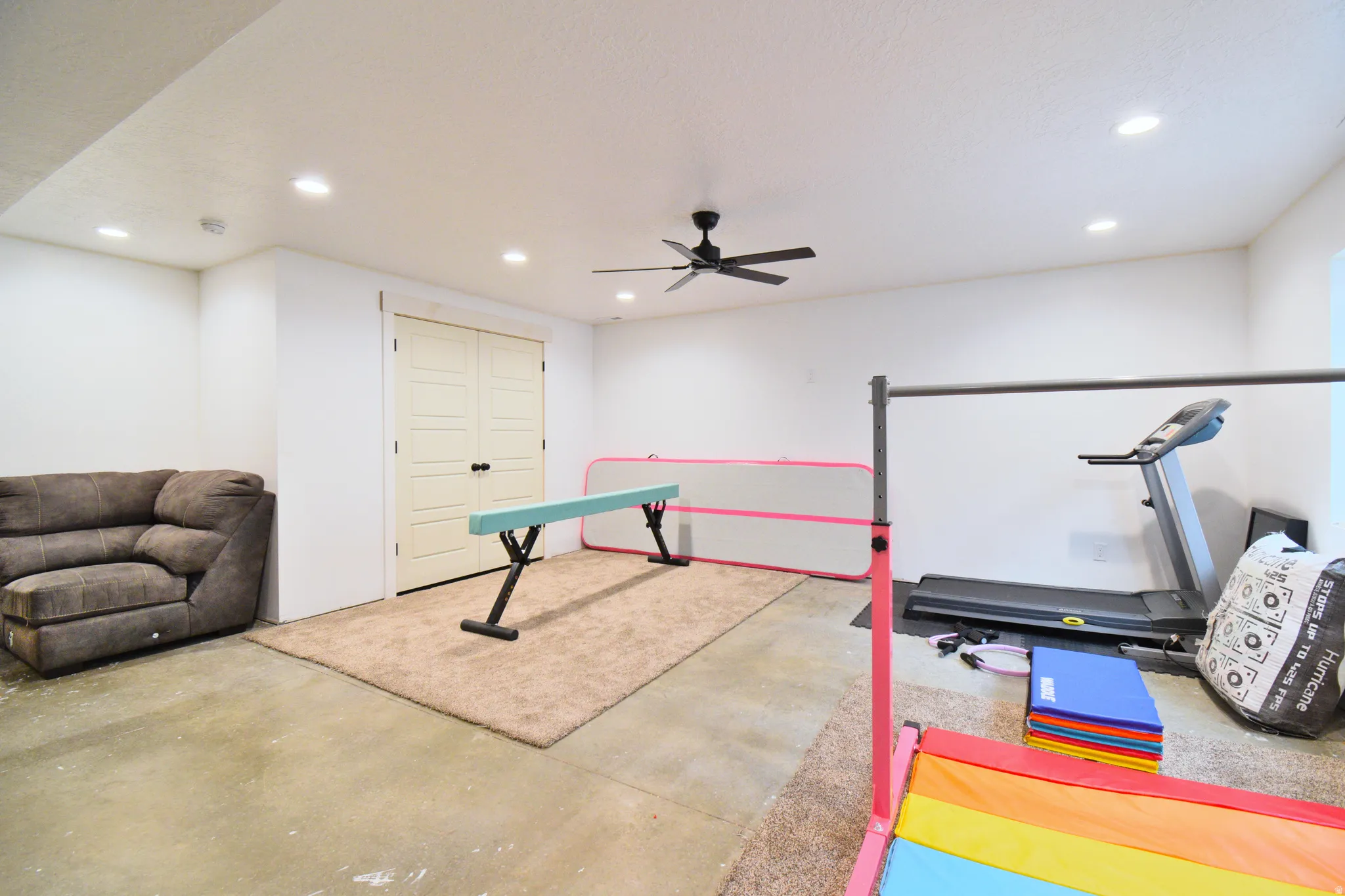 Exercise area featuring concrete flooring, recessed lighting, and ceiling fan