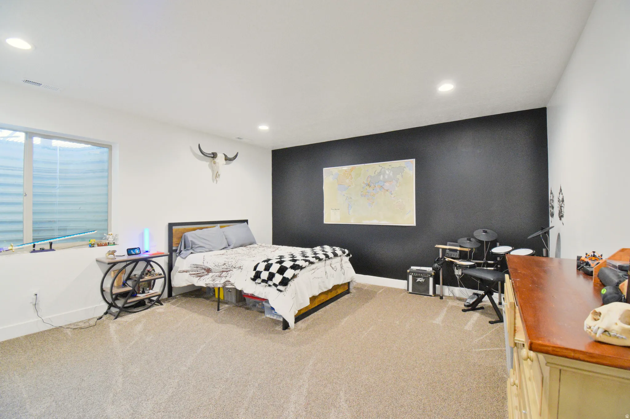 Bedroom featuring light carpet, an accent wall, and recessed lighting