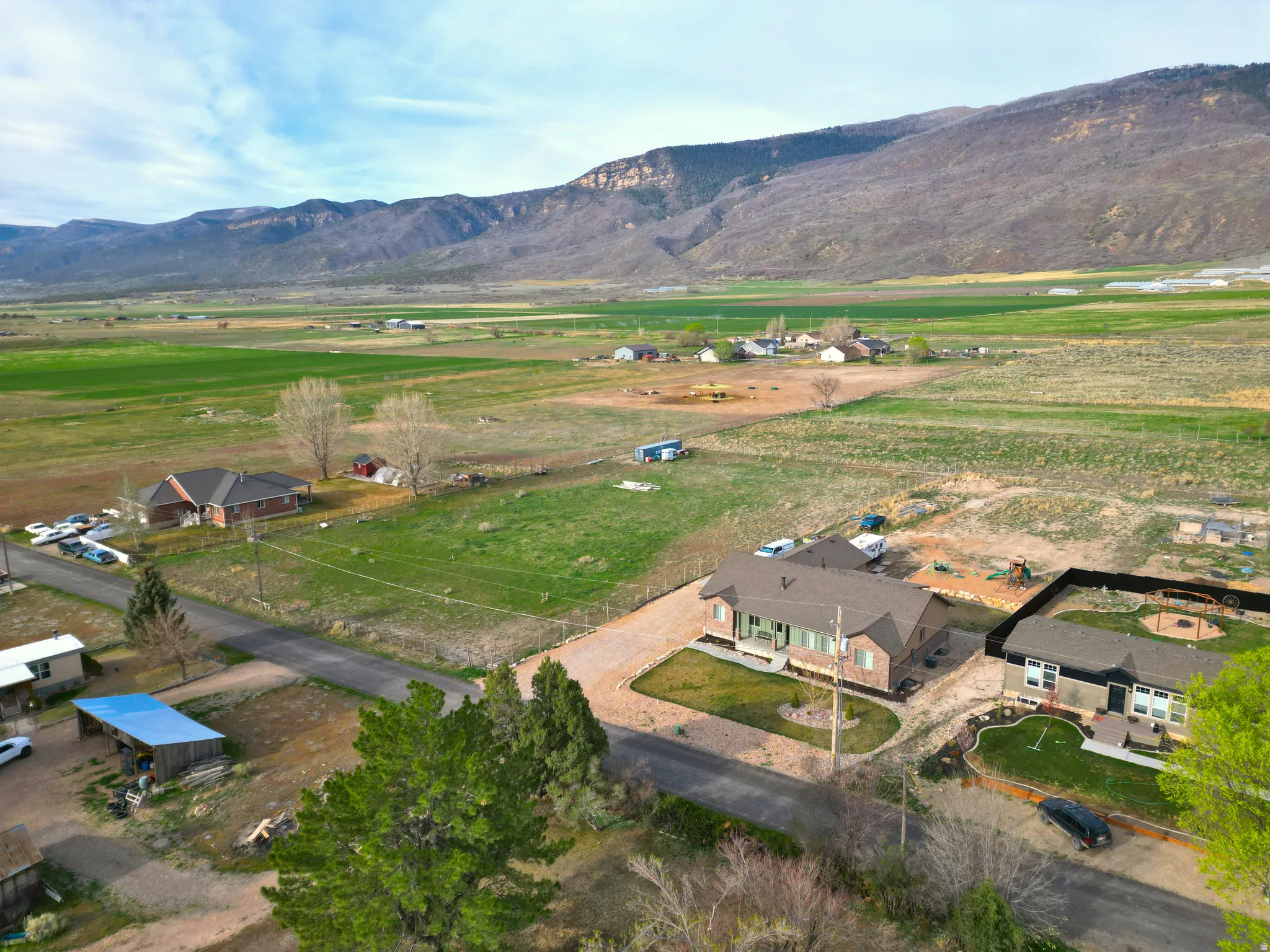Aerial view of property and surrounding area featuring rural landscape and mountains