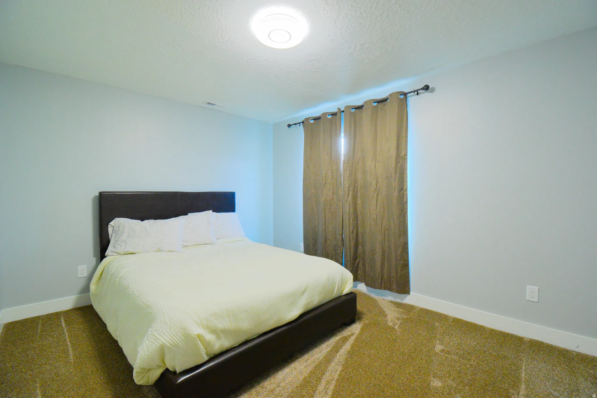 Bedroom featuring carpet flooring and a textured ceiling