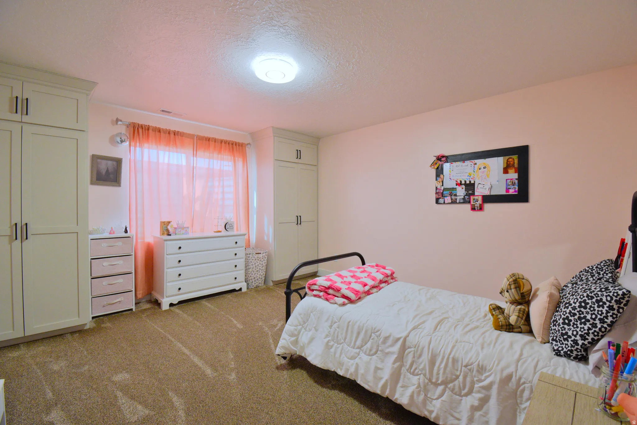 Bedroom with a textured ceiling and light carpet