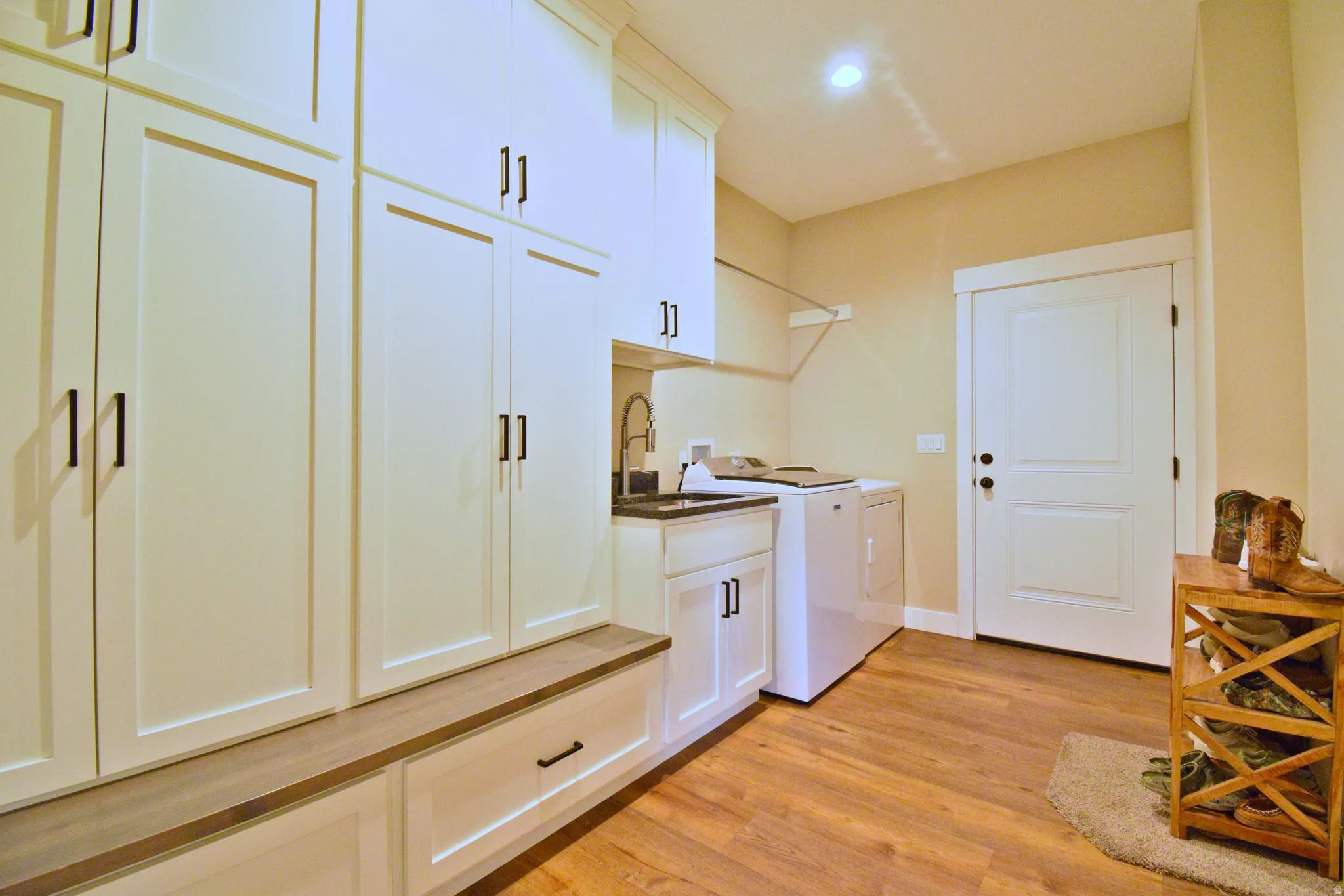 Laundry room with light wood-style floors, cabinet space, and independent washer and dryer