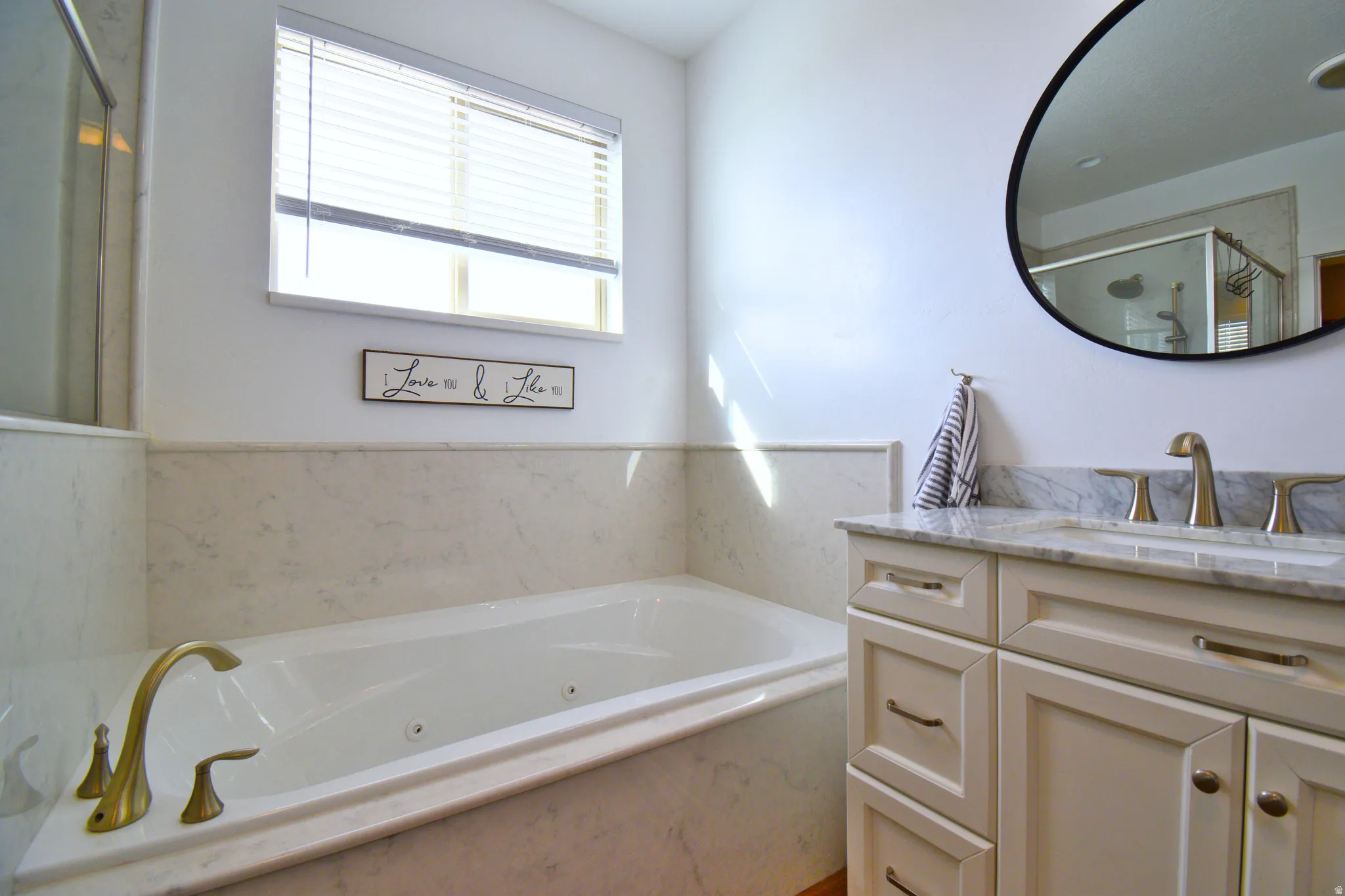 Full bathroom featuring vanity, a whirlpool tub, and a marble finish shower