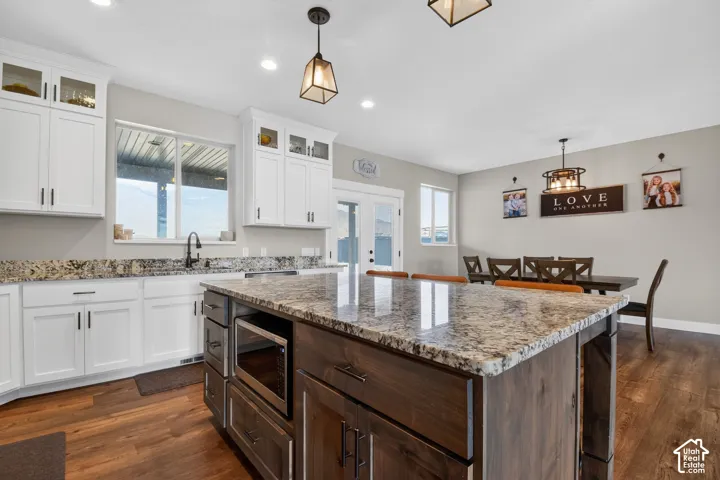 Kitchen island with a granite countertop and built-in microwave