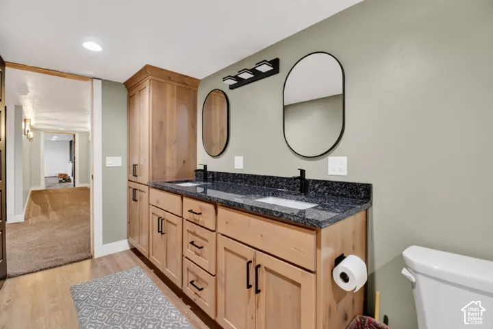 Dual vanity with dark granite countertop and integrated white sinks