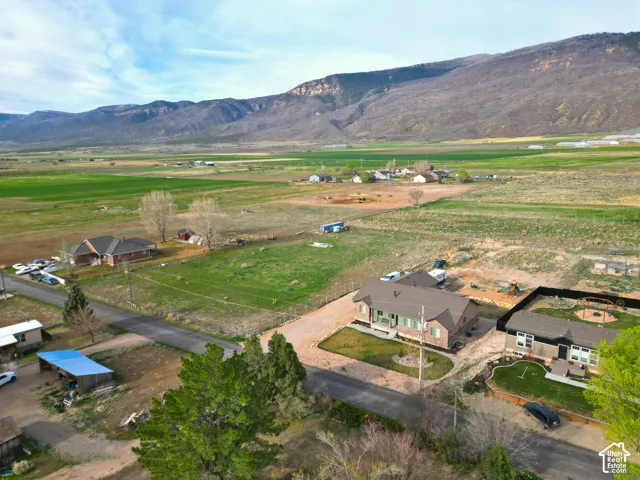 Aerial view of property and surrounding area featuring rural landscape and mountains