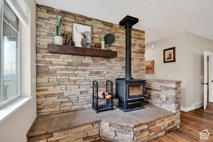 Stone-clad wood-burning stove with a substantial hearth and a rustic wood mantel
