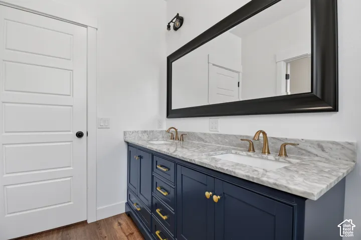 Dual vanity with a white countertop and integrated sinks, brushed gold faucets, and navy cabinetry with gold hardware