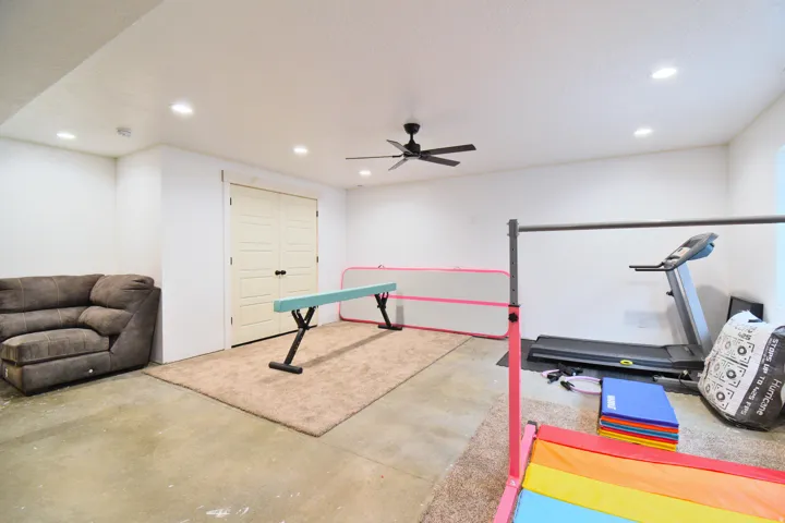 Exercise area featuring concrete flooring, recessed lighting, and ceiling fan