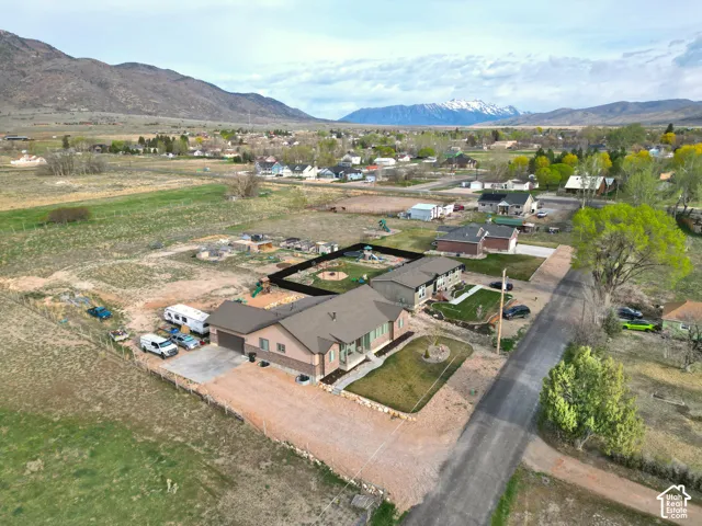 Aerial view of property and surrounding area with a mountainous background and nearby suburban area