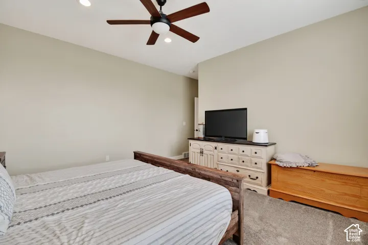 Neutral-toned walls complement the recessed lighting and ceiling fan
