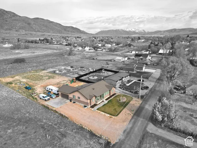 Aerial view of property and surrounding area with a mountainous background and nearby suburban area