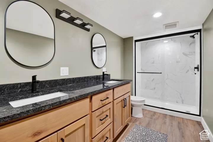 Double vanity with dark stone countertop and integrated rectangular sinks