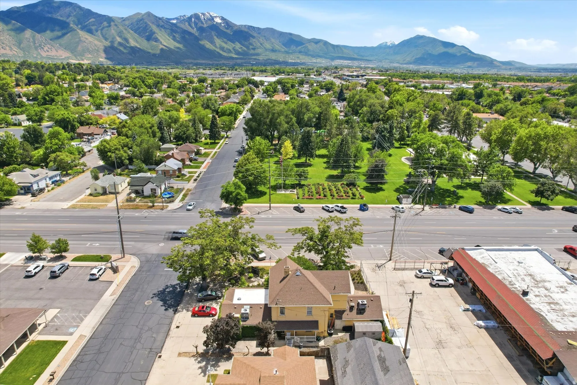 Aerial perspective showcasing a residential and commercial area with prominent mountain backdrops
