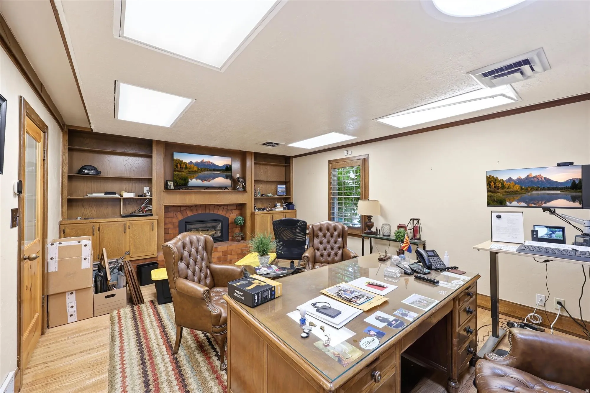 Spacious room featuring wood-finish flooring and a central area rug