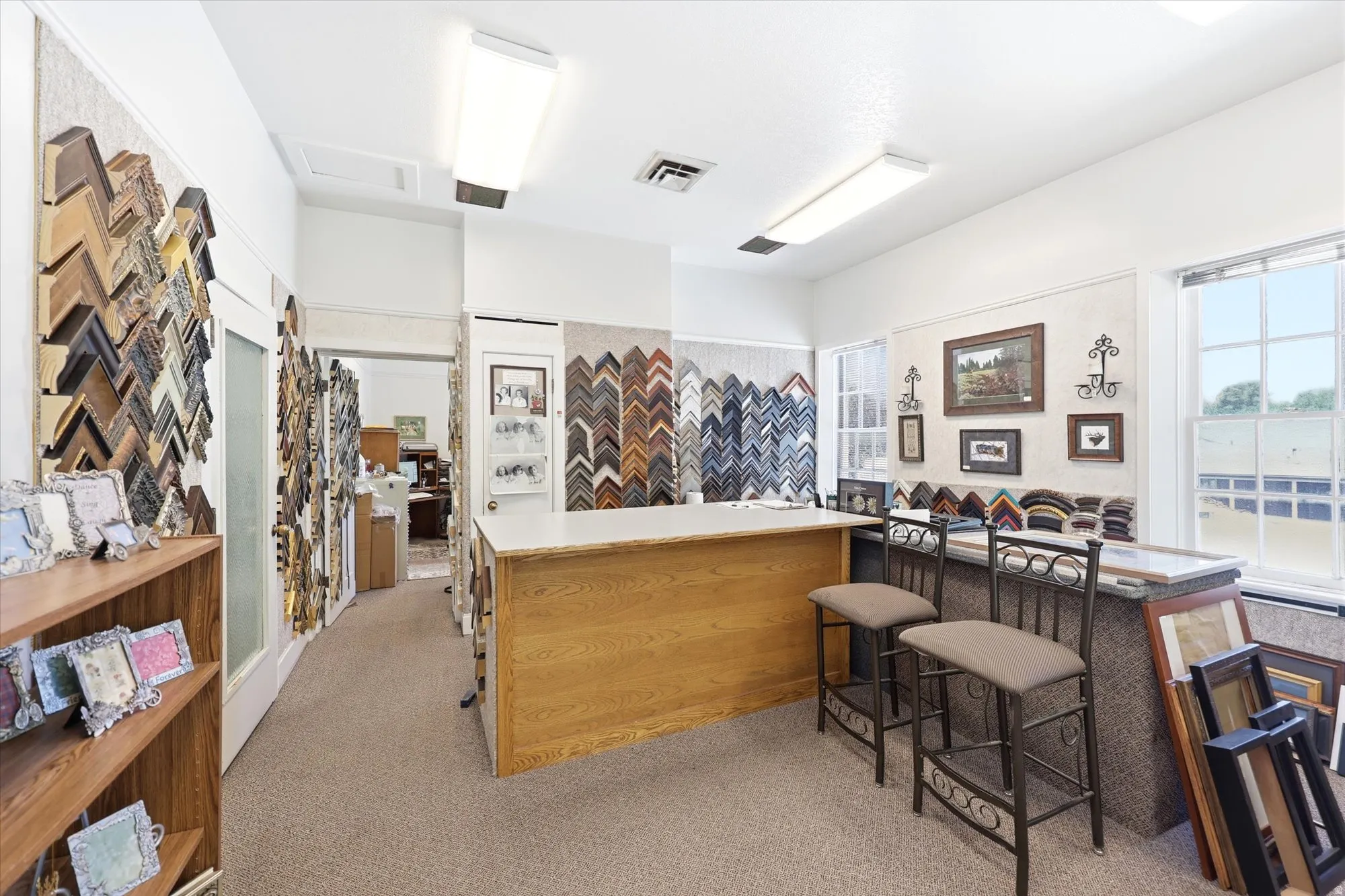 Commercial interior featuring carpet flooring, built-in counter, and two windows