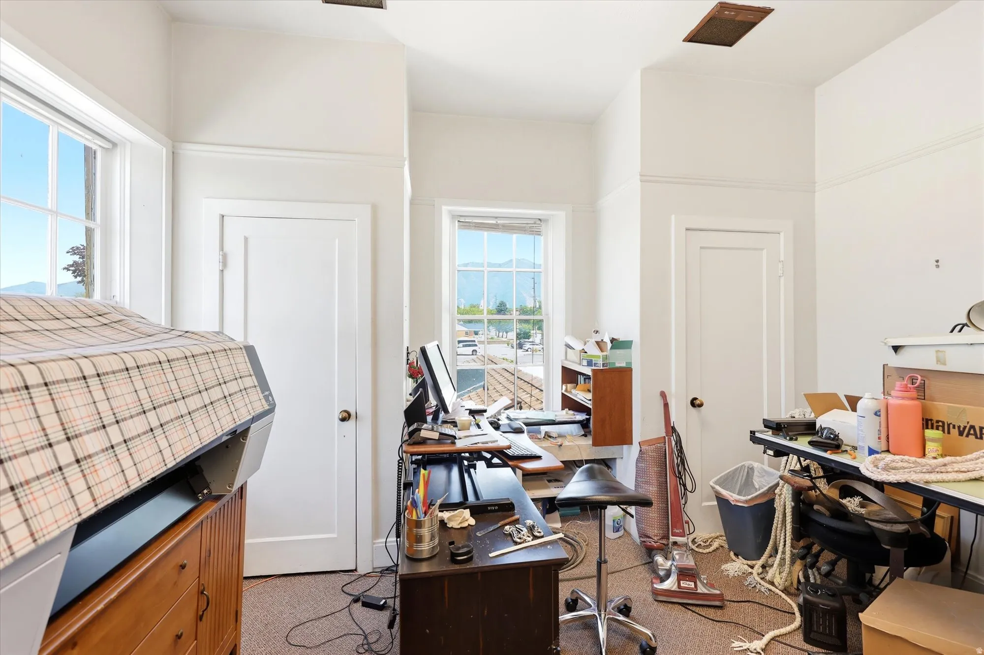 Room with multiple windows, two panel doors, and neutral wall paint