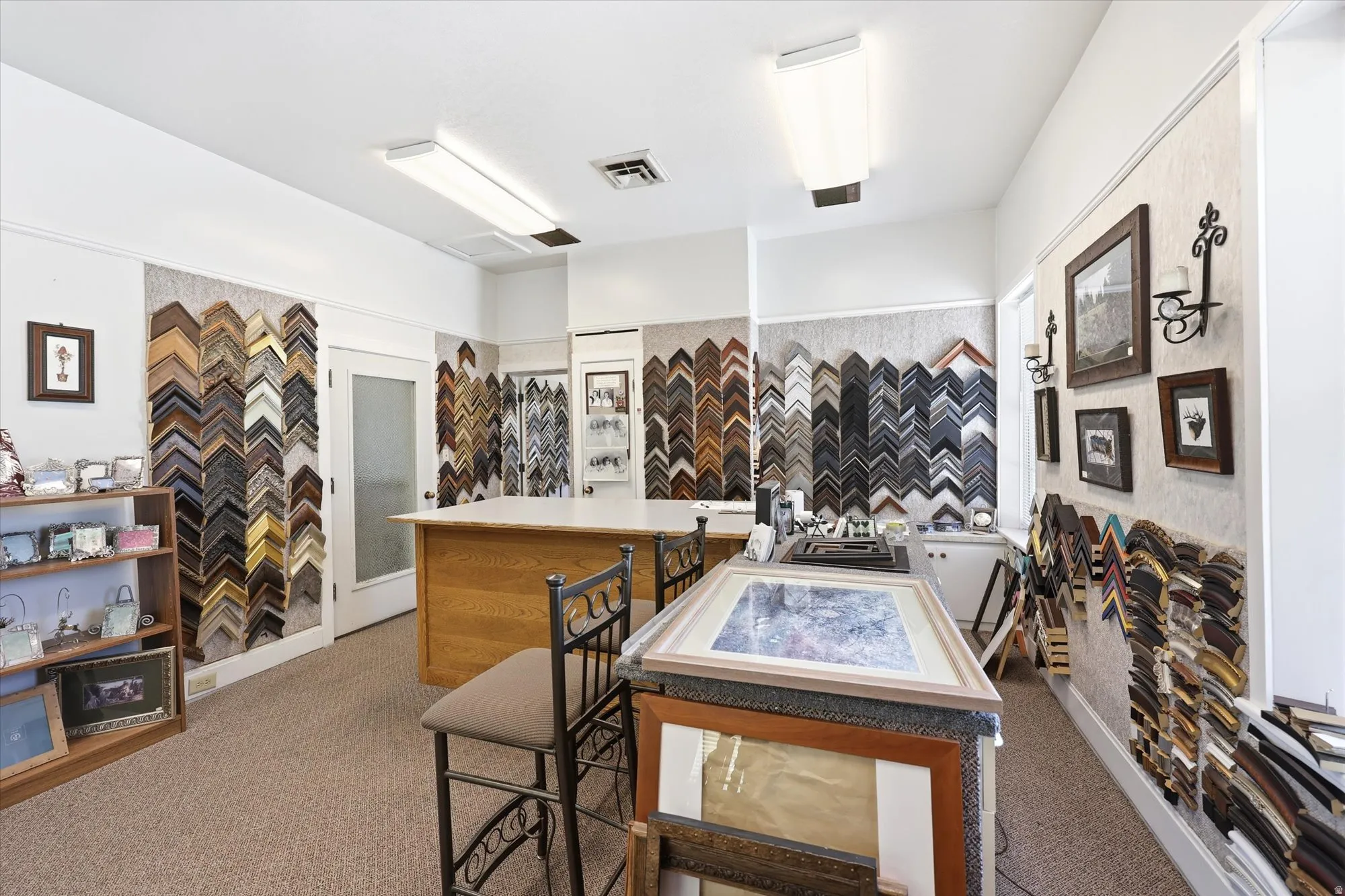 Commercial space featuring carpeted flooring, white walls, and bright overhead lighting
