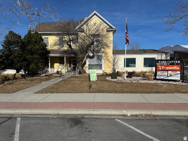 View of front of house featuring a porch and uncovered parking